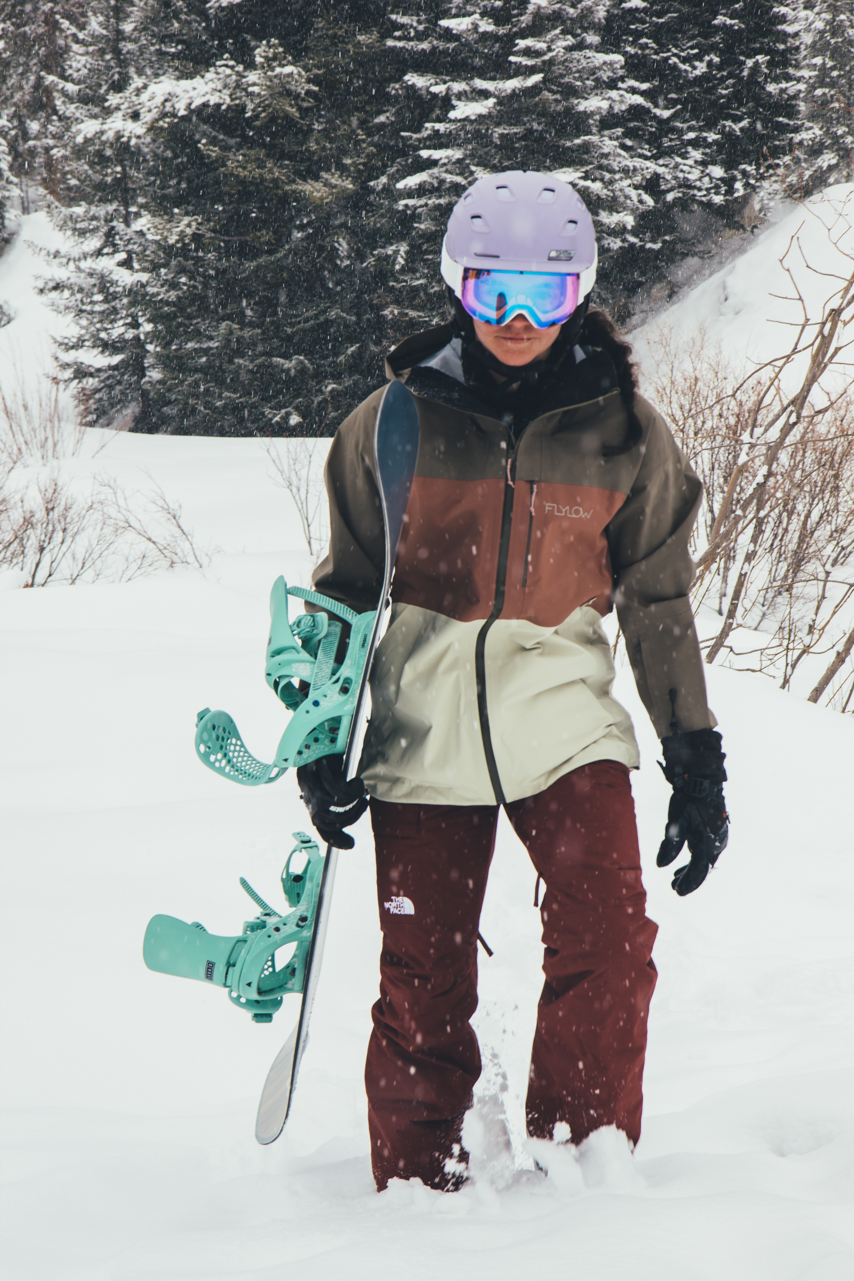 A woman with the snowboard she purchased from Sun & Ski Sports